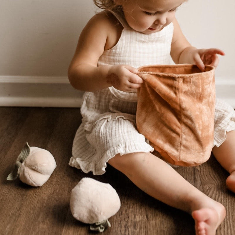 Young girl playing with a Momo Count and Toss set, using peach-shaped counting pieces for a fun and educational activity.